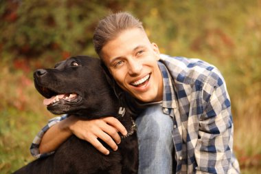 Gülümseyen adam ve sevimli köpek sonbahar günü açık havada