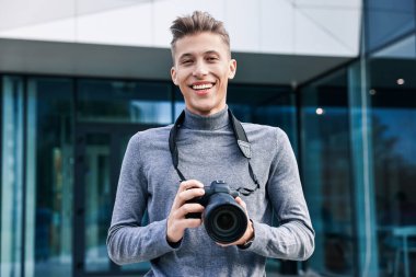 Binanın yakınında kamerası olan profesyonel bir fotoğrafçı.