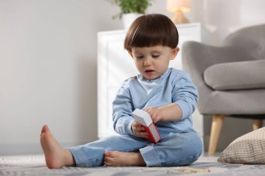 Küçük çocuk evde kibrit kutusuyla oynuyor. Çocuk tehlikede.