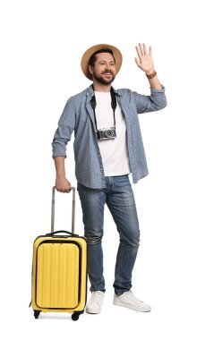 Şapkalı, bavullu ve beyaz arka planda kamerası olan mutlu bir turist.