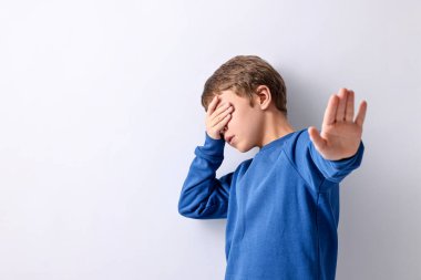 Korkak küçük çocuk arka planda gözleri kapatıyor. Metin için boşluk