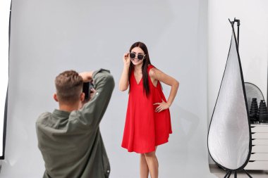Profesyonel fotoğraf stüdyosunda modelle çalışan bir fotoğrafçı.