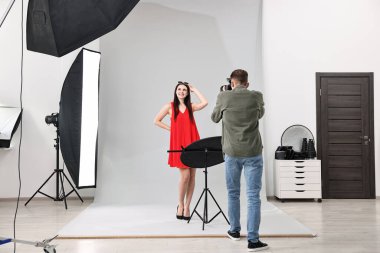 Profesyonel fotoğraf stüdyosunda modelle çalışan bir fotoğrafçı.