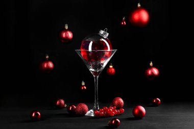 Mücevherlerle süslenmiş Noel kokteylinin yaratıcı sunumu ve siyah masanın üzerindeki cam.