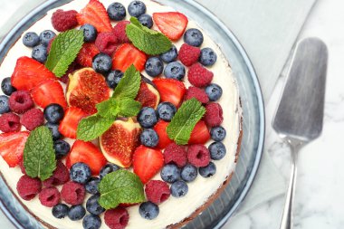 Lezzetli çikolatalı kek, böğürtlenli ve beyaz mermer masada sunucu, üst manzara.