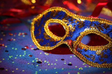Renkli arka planda güzel bir karnaval maskesi ve konfeti, yakın plan