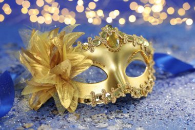 Mavi parıltılı arka planda güzel bir karnaval maskesi bulanık ışıklara karşı, yakın plan. Bokeh etkisi