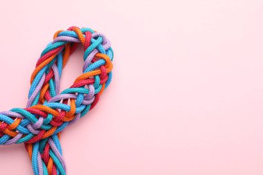Pembe arka planda örülmüş renkli ipler, yazı için yeri olan üst görünüm. Birlik kavramı