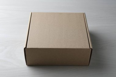 Beyaz ahşap arka planda boş bir karton kutu. Tasarım için model