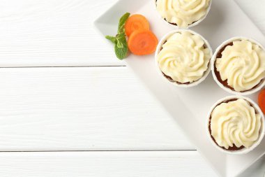 Taze sebzeli havuçlu kekler ve beyaz ahşap masada nane şekeri. Metin için boşluk