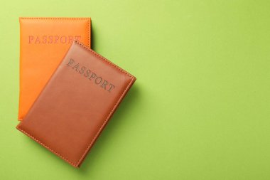 Yeşil arka planda renkli pasaportlar, üst manzara. Metin için boşluk