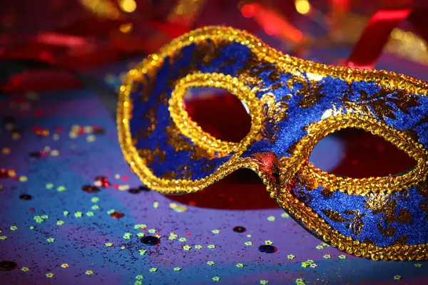 Renkli arka planda güzel bir karnaval maskesi ve konfeti, yakın plan