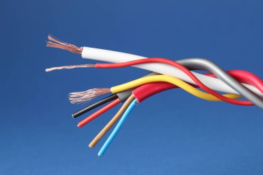 Mavi arka planda birçok sökülmüş elektrik kablosu, yakın plan