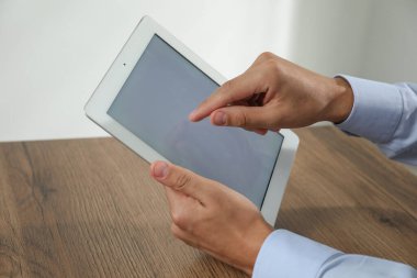 İşadamı ahşap masada tablet kullanıyor, yakın plan. Modern teknoloji