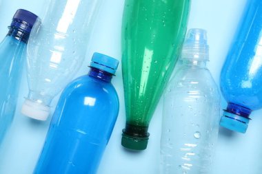 Işık arka planında birçok plastik şişe, üst görünüm