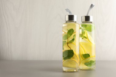 Açık gri masada içinde nane olan limonlu su, metin için boşluk.