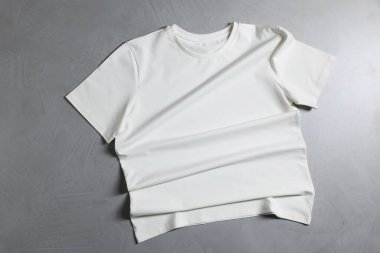 Gri desenli arka planda bir tişört, üst görünümde.