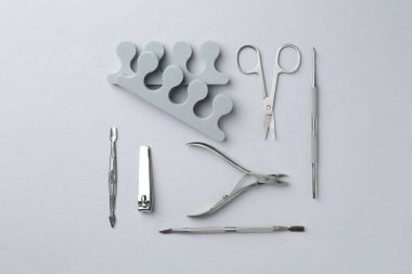 Açık gri arkaplan üzerinde pedikür araçları kümesi, düz yatıyordu