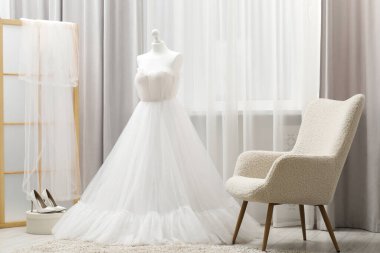 Manken üzerinde güzel bir gelinlik ve butikte ayakkabılar.