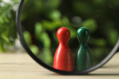 İnsan kaynakları konsepti. Tahta masadaki büyüteçten, bulanık arkaplana, yakın plan renk figürlerine bakıyorum.