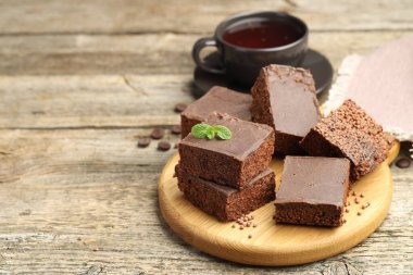 Lezzetli çikolatalı pilav çubukları ve ahşap masada çay, metin için yer.