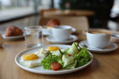 Kafedeki ahşap masada nefis bir kahvaltı, yakın plan.