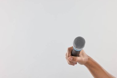 Açık gri arka planda mikrofonu olan adam, yakın plan. Metin için boşluk