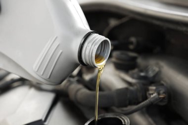 Araba motoruna motor yağı dökülüyor, yakın plan.