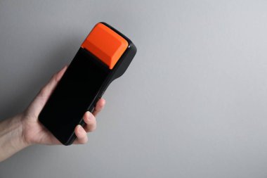 Gri arka planda ödeme terminali olan kadın, yakın plan. Metin için boşluk