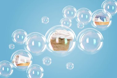 Several soap bubbles with laundry inside and empty ones floating on light blue background clipart