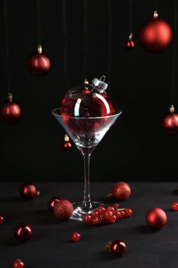 Mücevherlerle süslenmiş Noel kokteylinin yaratıcı sunumu ve siyah masanın üzerindeki cam.