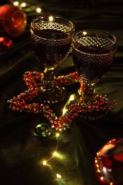 Kırmızı şaraplı bardaklar ve masada güzel bir Noel dekoru.