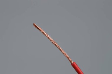 Açık gri arkaplanda kırmızı şeritli elektrik kablosu, yakın plan.