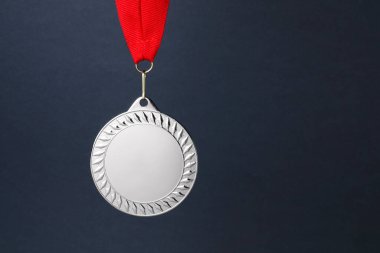Koyu gri arka planda kırmızı kurdeleli gümüş madalya, metin için boşluk