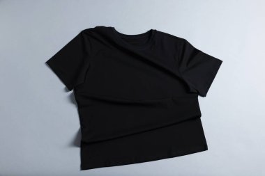 Gri arkaplanda bir tişört, üstten.