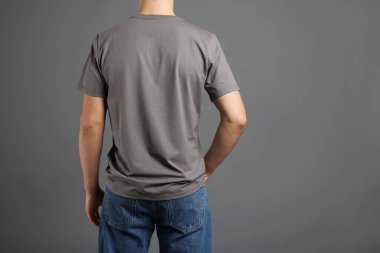 Gri arka planda, şık tişörtlü bir adam. Tasarım için model