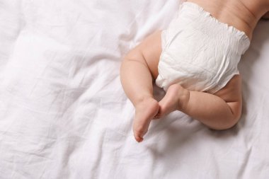 Yatakta bebek bezi takmış şirin bir bebek, manzaralı. Metin için boşluk