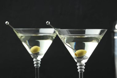 Siyah arka planda zeytinli martini kokteyli, yakın plan.