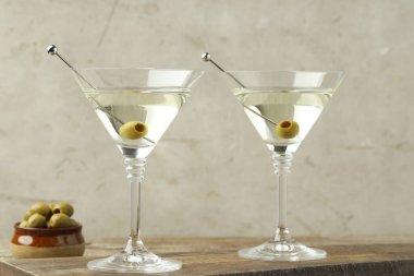 Ahşap masada zeytinli martini kokteyli.