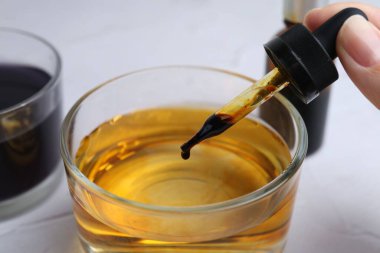 İyot nişastası testi. Beyaz masada iyot damlatan kadın, yakın plan.