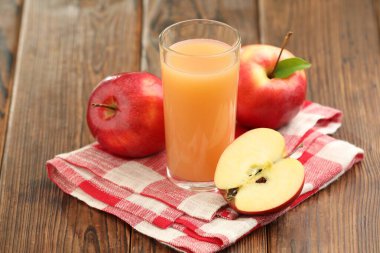 Lezzetli elma suyu ve ahşap masada taze meyveler.