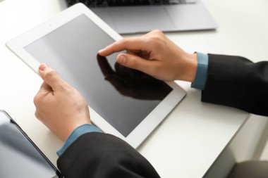 Beyaz masada tablet kullanan bir iş kadını, yakın plan. Modern teknoloji