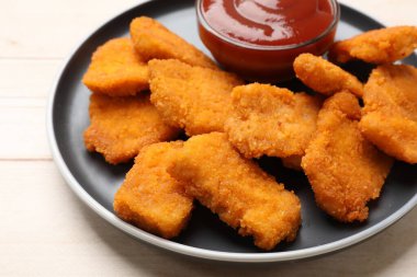 Lezzetli tavuk nugget ve sos ahşap masada, yakın plan.