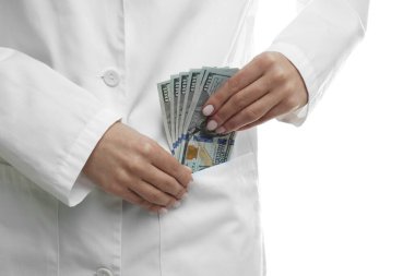 Yozlaşma konsepti. Doktor cebine dolar banknotları koyuyor, beyaz arka planda, yakın plan