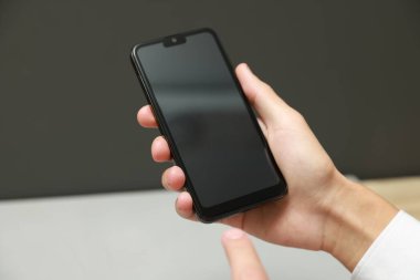 Bulanık arkaplanda boş ekranlı akıllı telefon kullanan adam, kapat
