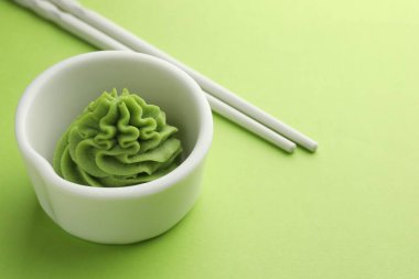 Kapta sıcak wasabi macunu ve yeşil masada yemek çubukları, yakın plan. Metin için boşluk