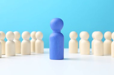 Masadaki beyazlar arasında mavi bir figür. Rekabet konsepti