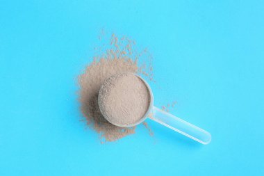 Protein tozu ve açık mavi arka planda kepçe, üst görünüm