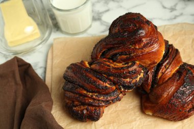 Beyaz mermer masada haşhaş tohumlu lezzetli çörekler, yakın plan.