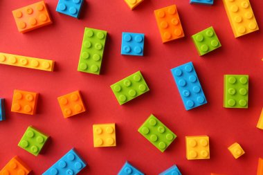 İnşaat oyuncağı. Kırmızı zemin üzerinde renkli tuğlalar, düz yatıyordu